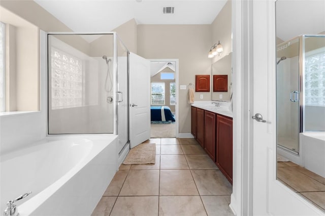 ensuite bathroom featuring visible vents, a shower stall, a garden tub, and vanity