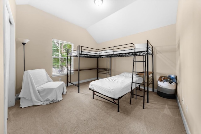 bedroom featuring baseboards, lofted ceiling, and carpet floors