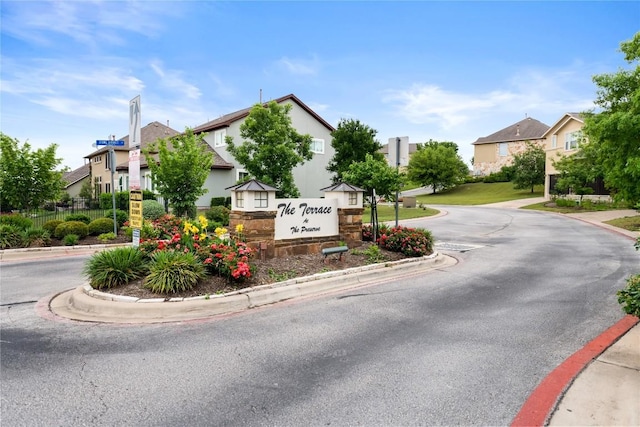 community / neighborhood sign with a residential view and fence