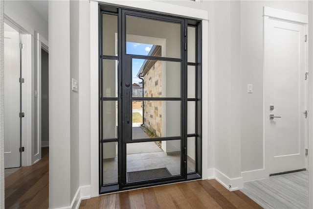 foyer with plenty of natural light, wood finished floors, and baseboards