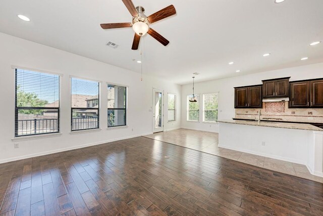 3909 Vinalopo Dr, Austin, TX 78738 - unfurnished living room featuring a ceiling fan, wood finished floors, a sink, baseboards, and recessed lighting