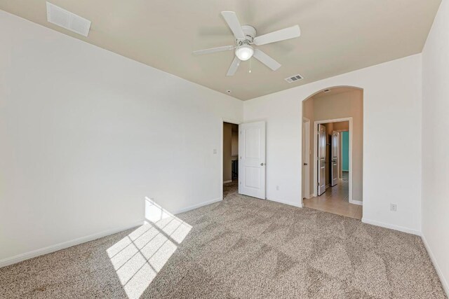 3909 Vinalopo Dr, Austin, TX 78738 - unfurnished bedroom with light carpet, arched walkways, baseboards, and a ceiling fan