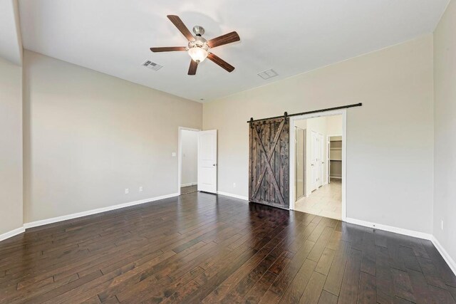 3909 Vinalopo Dr, Austin, TX 78738 - empty room with ceiling fan, a barn door, wood-type flooring, and baseboards