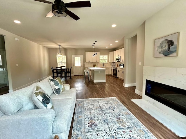 128 Heleakala Dr, Bastrop, TX 78602 - living room featuring recessed lighting, dark wood finished floors, ceiling fan, and a fireplace