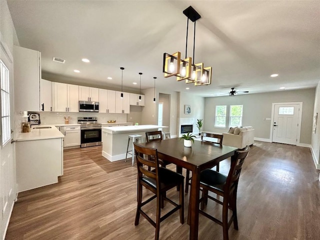 128 Heleakala Dr, Bastrop, TX 78602 - dining area featuring ceiling fan, recessed lighting, baseboards, wood finished floors, and visible vents