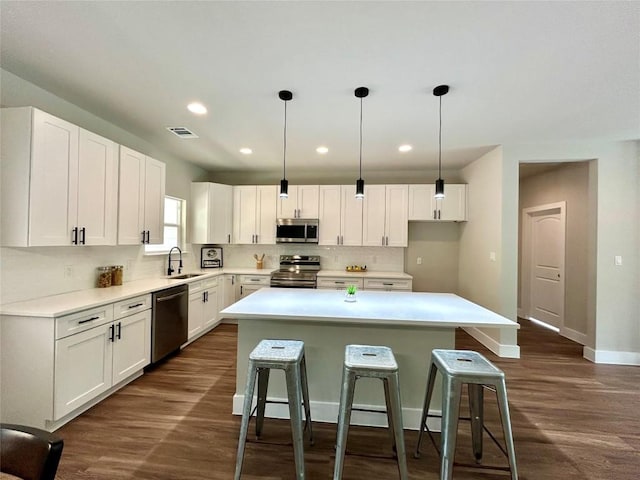 128 Heleakala Dr, Bastrop, TX 78602 - kitchen featuring visible vents, a kitchen island, baseboards, a sink, and stainless steel appliances