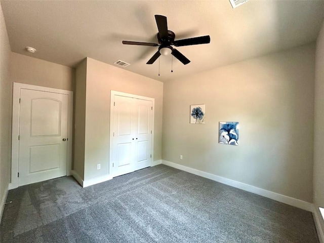 128 Heleakala Dr, Bastrop, TX 78602 - unfurnished bedroom featuring visible vents, a closet, baseboards, dark carpet, and a ceiling fan