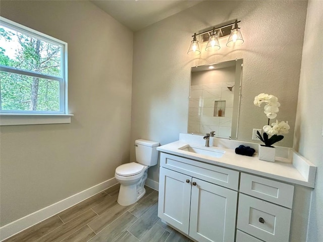 128 Heleakala Dr, Bastrop, TX 78602 - bathroom featuring vanity, wood finished floors, toilet, baseboards, and a tile shower