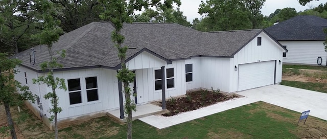 128 Heleakala Dr, Bastrop, TX 78602 - view of front of house with board and batten siding, roof with shingles, and a garage