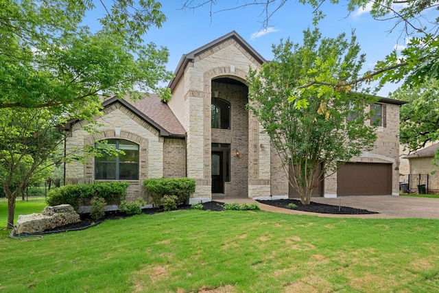 view of front of home with a front yard, a garage, driveway, stone siding, and brick siding