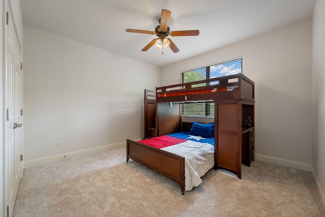 bedroom with baseboards, a ceiling fan, and light colored carpet