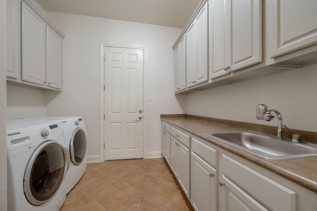 washroom featuring independent washer and dryer, light tile patterned floors, cabinet space, a sink, and baseboards