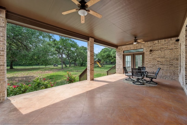 view of patio featuring a playground, outdoor dining area, fence, a ceiling fan, and french doors