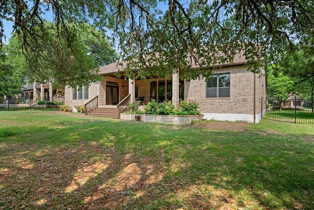 view of front of house with fence, a front yard, and brick siding