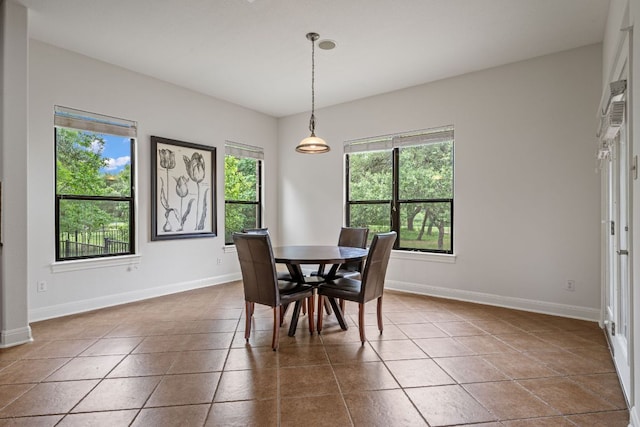 dining area featuring baseboards and dark tile patterned flooring