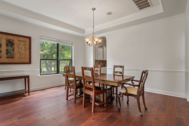 dining space with ornamental molding, a raised ceiling, visible vents, and baseboards