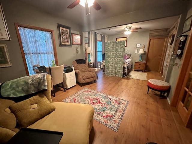 living room with light wood-style floors and a ceiling fan