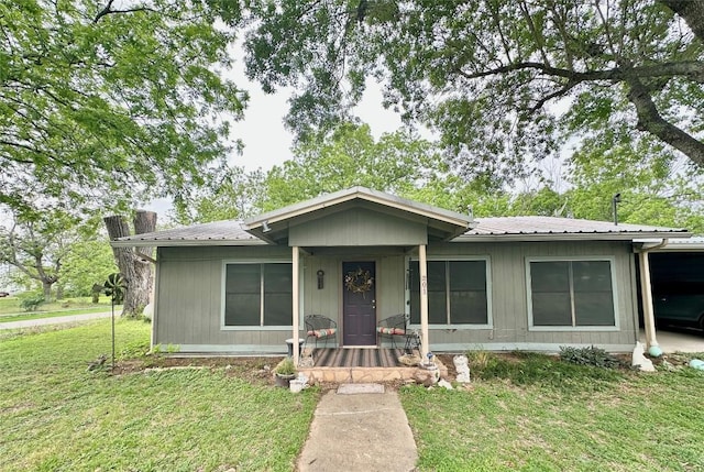 ranch-style home featuring a front lawn and metal roof