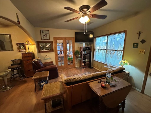 201 E Bluebonnet Ln, Johnson City, TX 78636 - living room featuring wood finished floors, a ceiling fan, french doors, arched walkways, and baseboards