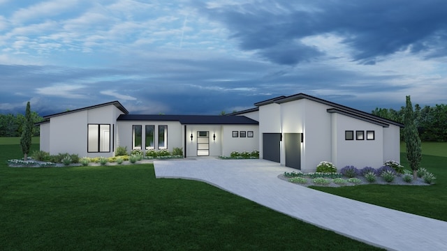 contemporary home featuring a front yard, driveway, an attached garage, and stucco siding