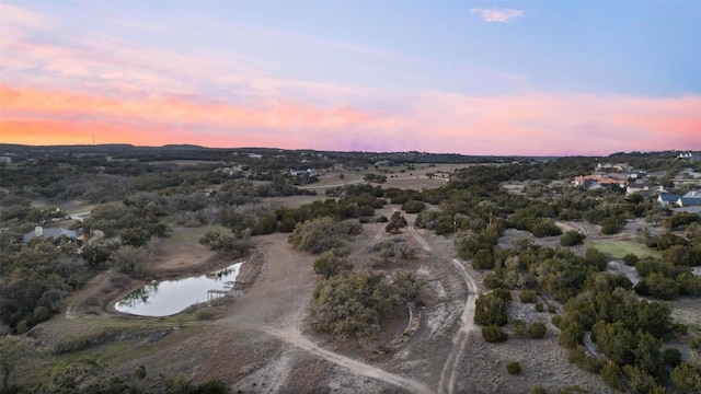 aerial view at dusk featuring a water view