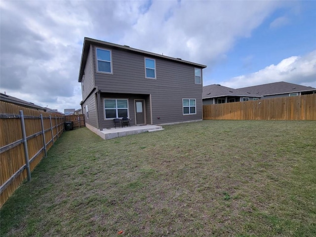 back of property featuring a patio, a yard, and a fenced backyard