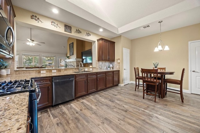 kitchen with a sink, stainless steel appliances, visible vents, backsplash, and lofted ceiling