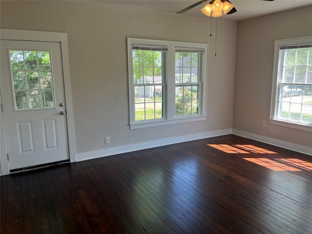 interior space with a ceiling fan, dark wood-style floors, and baseboards