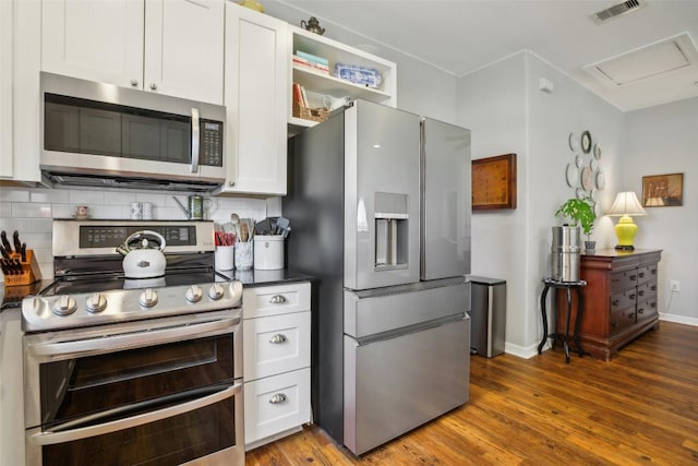 103 Bonham Ln, Paige, TX 78659 - kitchen featuring stainless steel appliances, dark countertops, decorative backsplash, and white cabinets