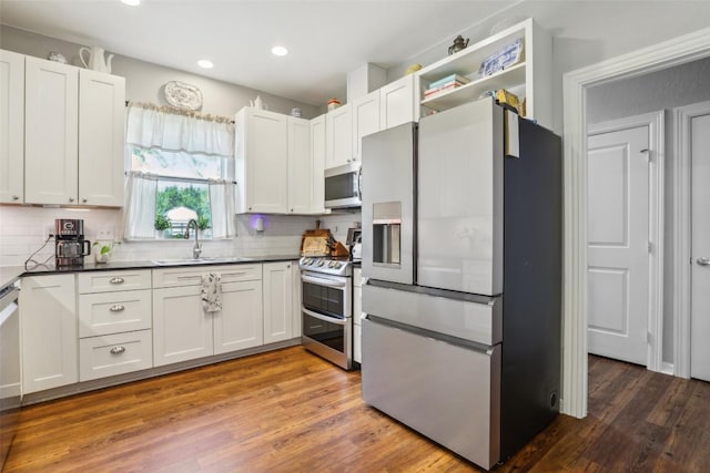 103 Bonham Ln, Paige, TX 78659 - kitchen featuring appliances with stainless steel finishes, a sink, backsplash, dark countertops, and recessed lighting