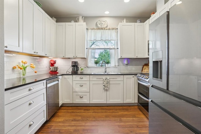 103 Bonham Ln, Paige, TX 78659 - kitchen featuring stainless steel appliances, a sink, recessed lighting, dark countertops, and backsplash