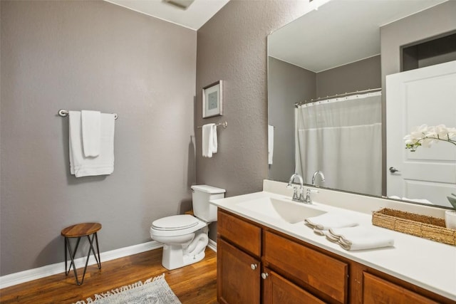 103 Bonham Ln, Paige, TX 78659 - full bathroom featuring toilet, wood finished floors, vanity, baseboards, and a textured wall