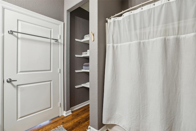 103 Bonham Ln, Paige, TX 78659 - bathroom featuring wood finished floors and curtained shower