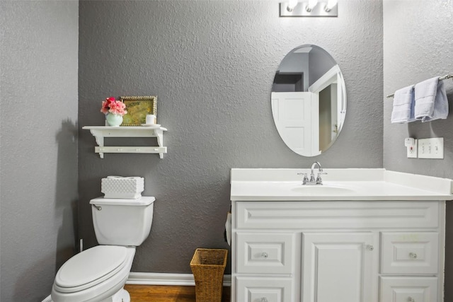 103 Bonham Ln, Paige, TX 78659 - half bathroom featuring vanity, toilet, and wood finished floors