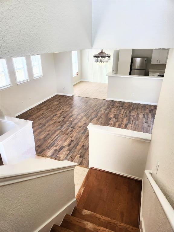 13520 Coomes Dr, Del Valle, TX 78617 - staircase featuring plenty of natural light, wood finished floors, and a textured ceiling