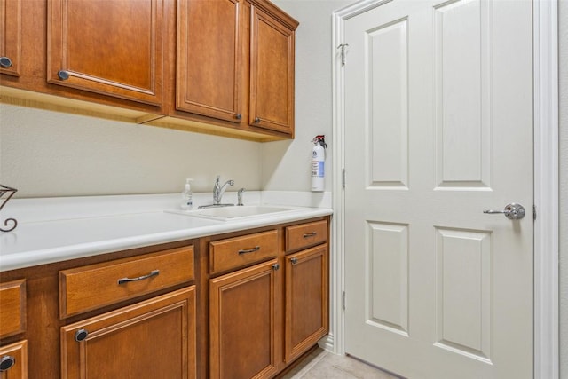 104 Emory Peak Trl, Georgetown, TX 78633 - laundry area featuring a sink and light tile patterned floors