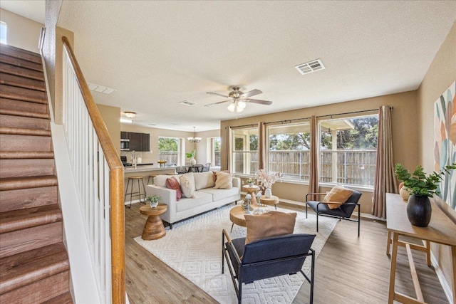 4108 Whitecrest Cv, Round Rock, TX 78681 - living area with light wood-type flooring, a ceiling fan, a textured ceiling, and stairway