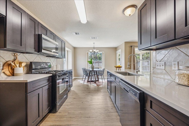 4108 Whitecrest Cv, Round Rock, TX 78681 - kitchen featuring appliances with stainless steel finishes, light wood-style flooring, decorative backsplash, a textured ceiling, and light countertops