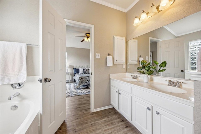 4108 Whitecrest Cv, Round Rock, TX 78681 - ensuite bathroom with ornamental molding, double vanity, wood finished floors, a tub, and ceiling fan