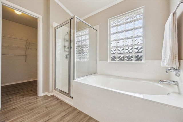 4108 Whitecrest Cv, Round Rock, TX 78681 - bathroom featuring a stall shower, a garden tub, a walk in closet, wood finished floors, and crown molding