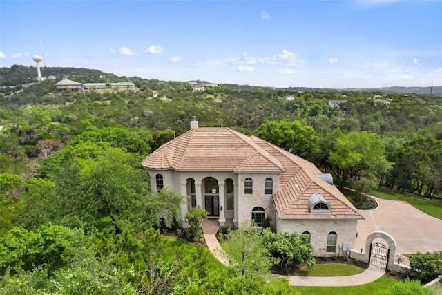 7800 Aspen Highlands Dr, Austin, TX 78746 - view of front of house featuring stone siding, a gate, a wooded view, and a chimney