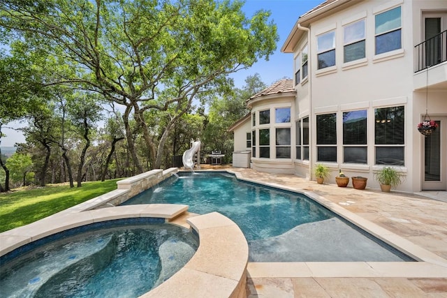 7800 Aspen Highlands Dr, Austin, TX 78746 - view of swimming pool with a water slide, a patio, and a pool with connected hot tub