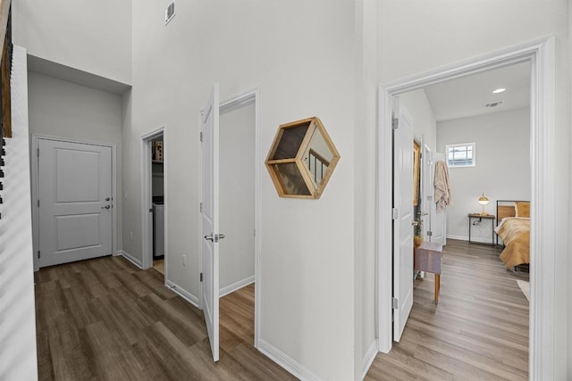 7901 Donnelley Dr, Austin, TX 78744 - hallway featuring a towering ceiling, wood finished floors, visible vents, and baseboards