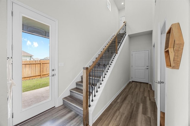 7901 Donnelley Dr, Austin, TX 78744 - stairway featuring a towering ceiling, visible vents, wood finished floors, and baseboards