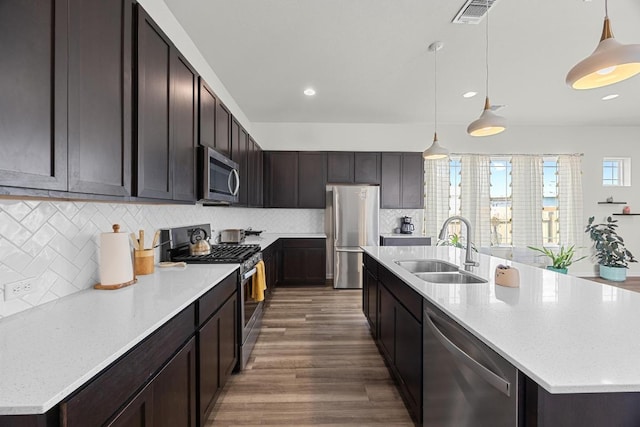 7901 Donnelley Dr, Austin, TX 78744 - kitchen featuring a sink, appliances with stainless steel finishes, visible vents, wood finished floors, and a center island with sink