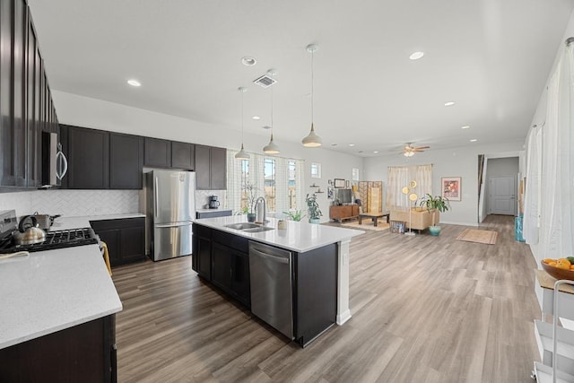 7901 Donnelley Dr, Austin, TX 78744 - kitchen with backsplash, a sink, appliances with stainless steel finishes, and light wood-type flooring