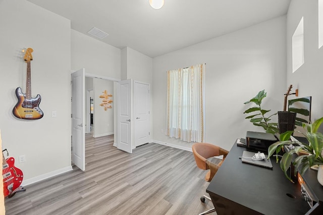 7901 Donnelley Dr, Austin, TX 78744 - office area with lofted ceiling, wood finished floors, visible vents, and baseboards