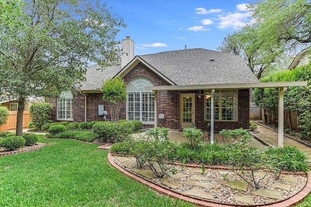 rear view of property with roof with shingles, fence, and brick siding