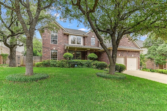 traditional-style home with a front lawn, driveway, brick siding, and fence