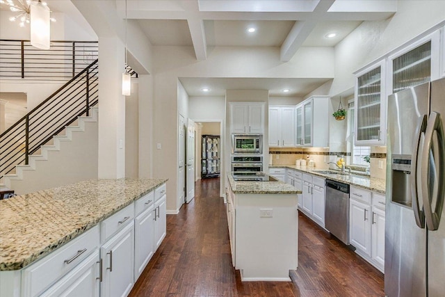 kitchen with a sink, decorative backsplash, a center island, coffered ceiling, and appliances with stainless steel finishes